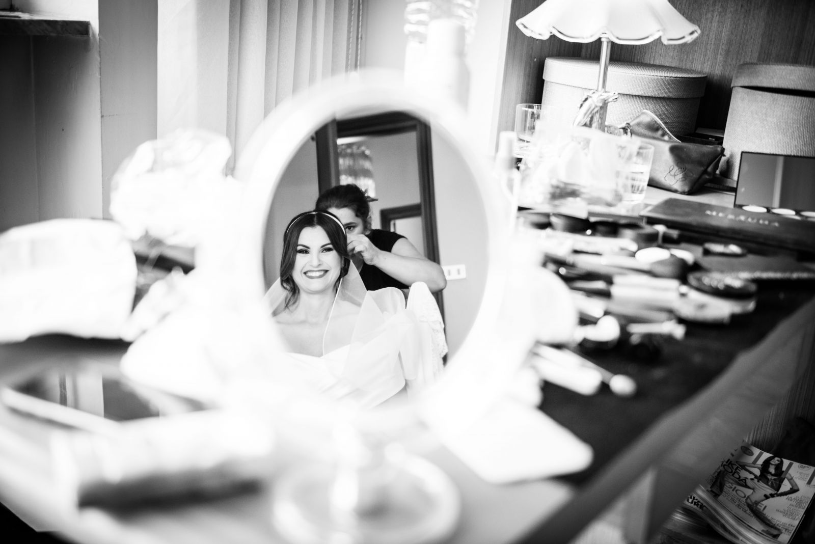 Sposa riflessa nello specchio della toeletta durante i preparativi, fotografia in bianco e nero