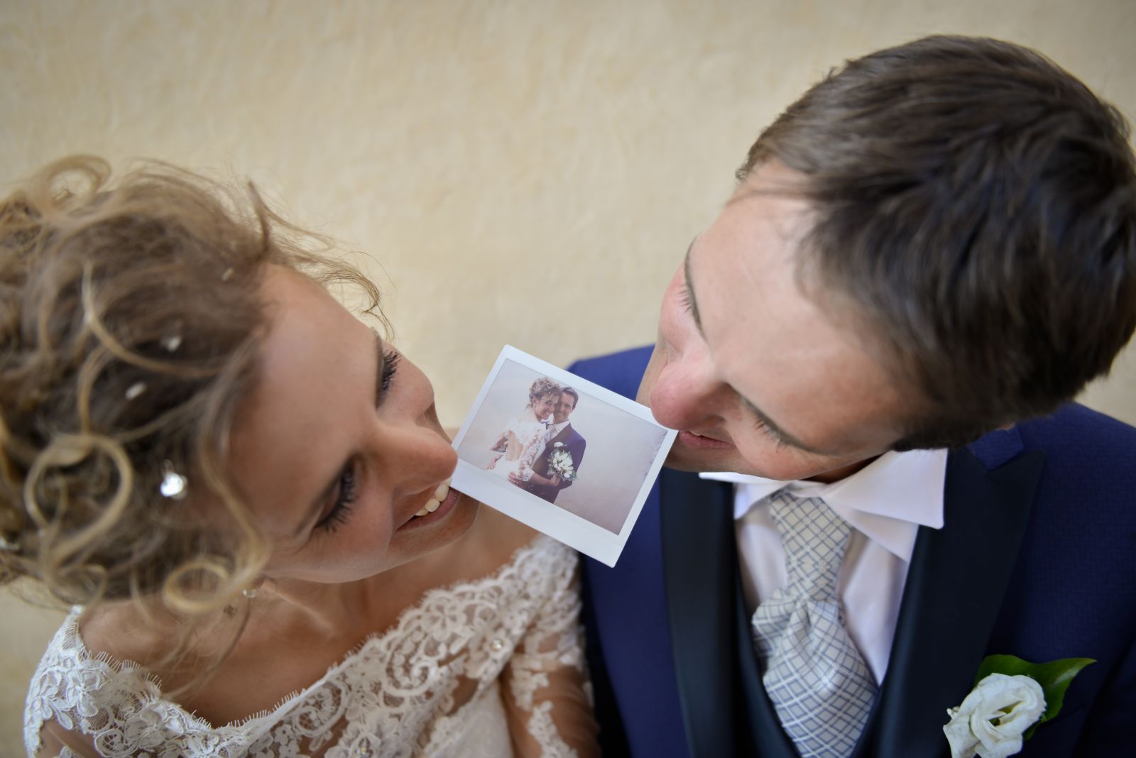 Sposa che ride guardando la polaroid tenuta in mano dallo sposo