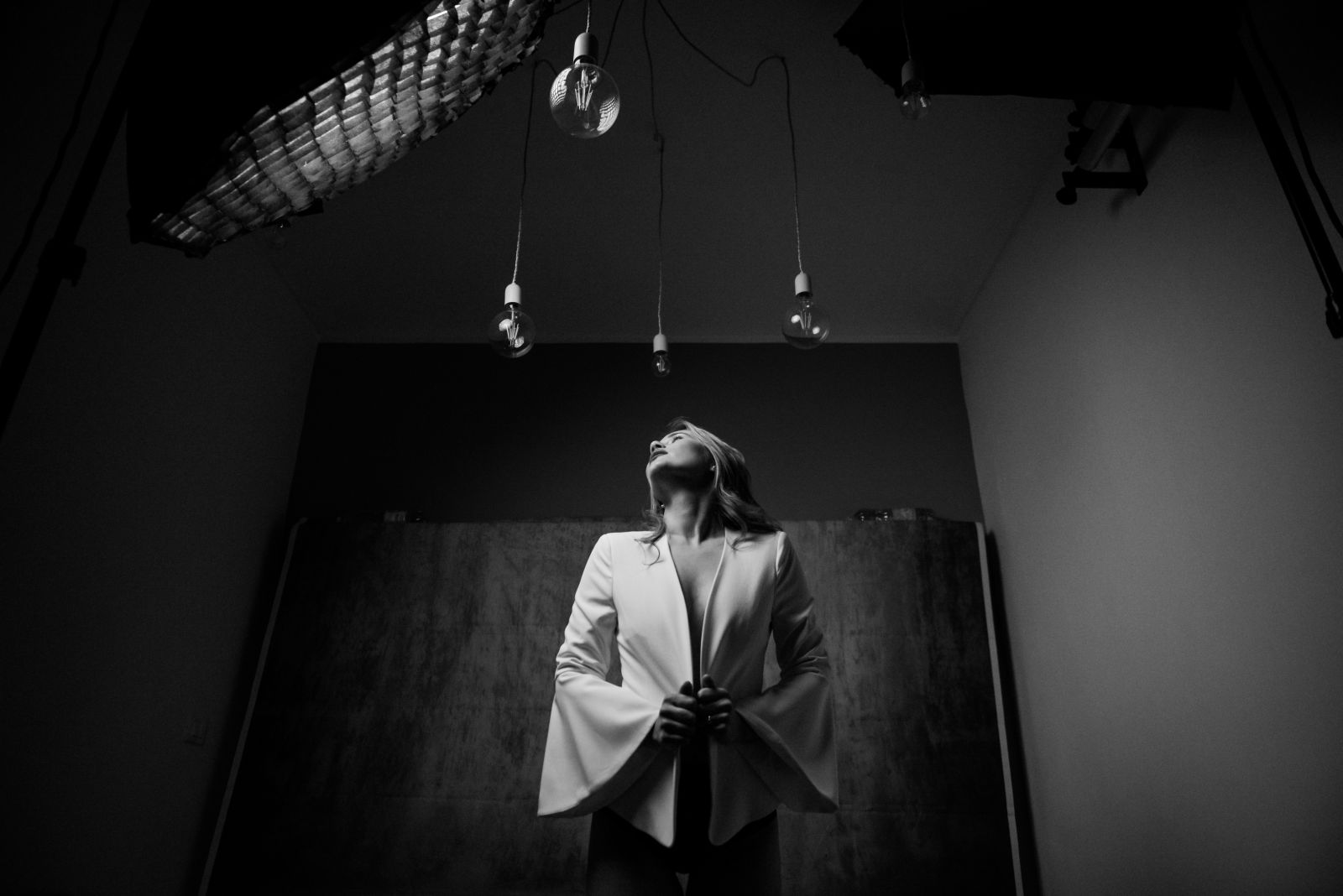 Sposo di spalle in una sala espositiva in penombra, fotografia in bianco e nero