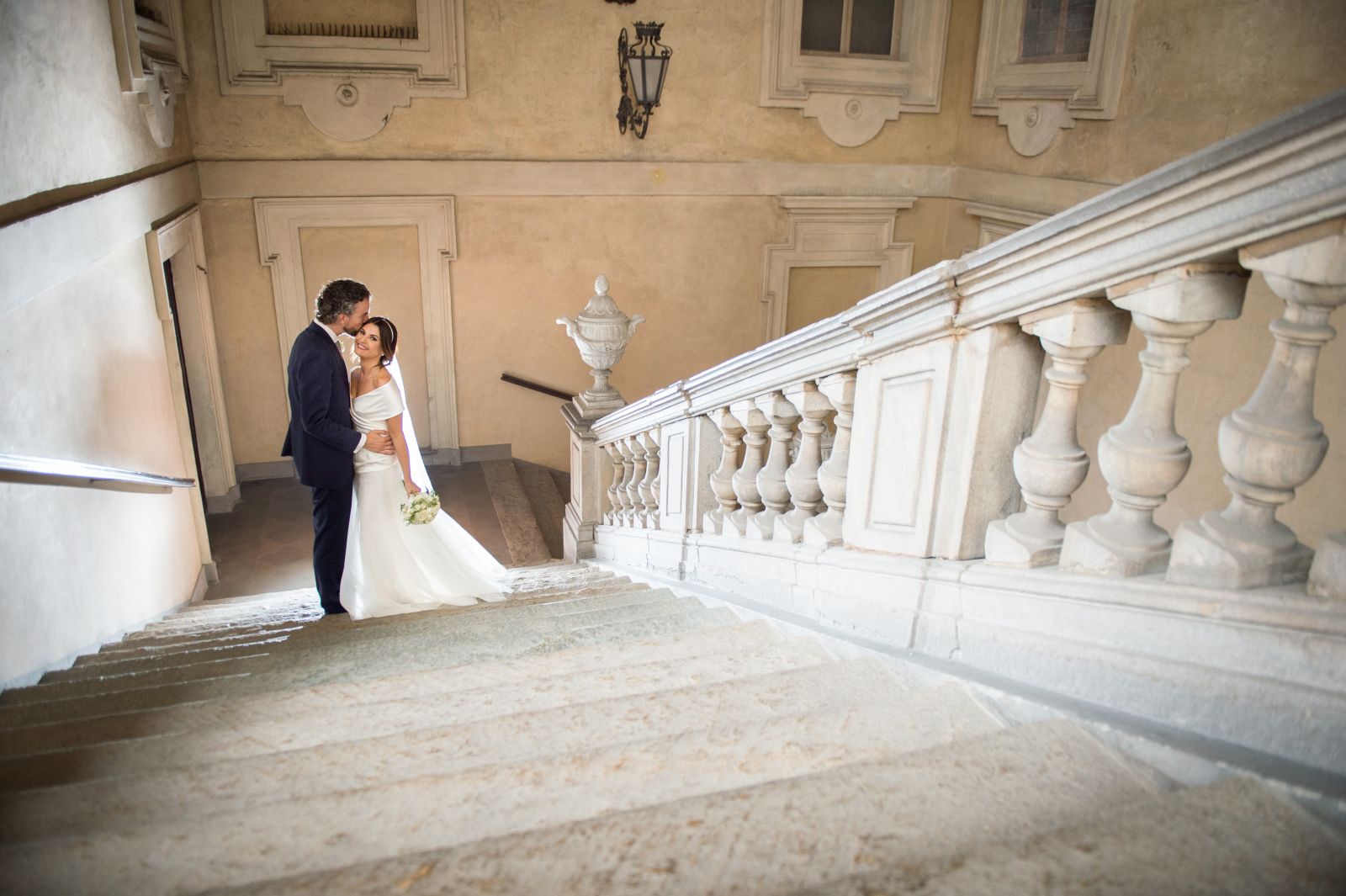 Sposa in cima a una scalinata di marmo con lo strascico disteso sui gradini